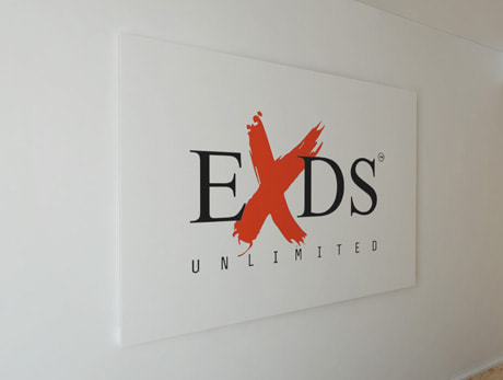 EXDS Unlimited logo printed on the wall