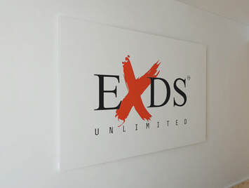 EXDS Unlimited logo printed on a wall